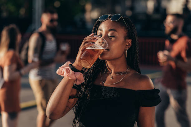beautiful african american woman drinking beer and having fun at music festival
